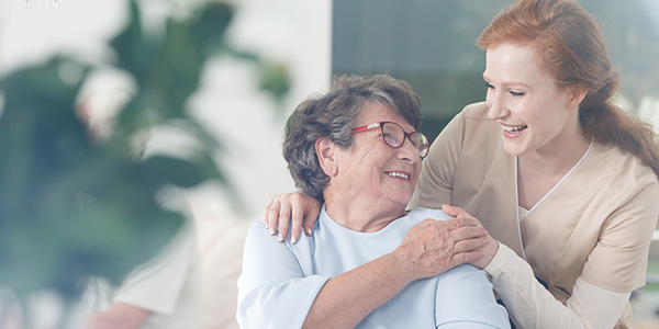 Nurse and patient at senior living community smiling